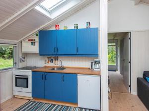 Nørre Nebelにある4 person holiday home in N rre Nebelの小さな家の中の青いキャビネット付きのキッチン