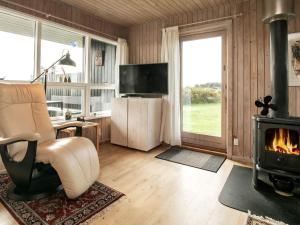 sala de estar con silla y chimenea en 5 person holiday home in L kken, en Løkken
