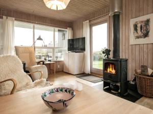 una sala de estar con estufa de leña. en 5 person holiday home in L kken, en Løkken