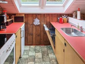 Nørre Nebelにある4 person holiday home in N rre Nebelのキッチン(シンク、赤いカウンタートップ付)