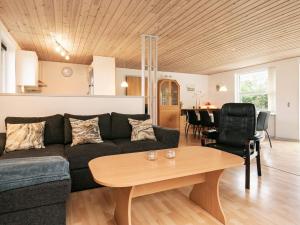 een woonkamer met een bank en een tafel bij Holiday home Spøttrup II in Spottrup