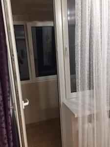 una puerta corredera de cristal con una ventana en el baño en Apartament simplu si confortabil, en Chişinău