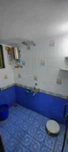 baño azul y blanco con aseo y lavamanos en VISAVA Home Stay, en Alibaug