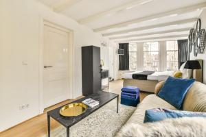 a living room with a couch and a table at Spiegelgracht Apartments with Canal View in Amsterdam