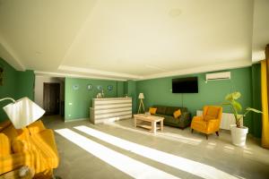 una sala de estar con paredes verdes y sillas amarillas. en Lemon, en Kutaisi