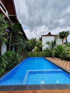 a large blue swimming pool in front of a house at Madee Spa & Resort in Ban Khok Lo