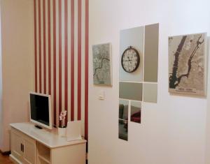 a room with a tv and a clock on a wall at JUNTO AL PILAR in Zaragoza