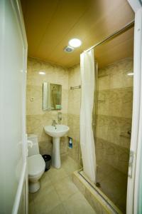 a bathroom with a toilet and a sink and a shower at Lemon in Kutaisi