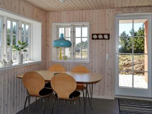 a dining room with a wooden table and chairs at 4 person holiday home in Fan in Fanø