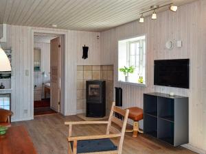 a living room with a television and a chair at 4 person holiday home in Fan in Fanø