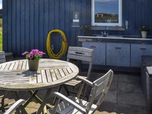 a wooden table and chairs on a patio at 6 person holiday home in Harbo re in Harboør