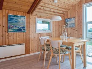 a dining room with a wooden table and chairs at 4 person holiday home in Hvide Sande in Bjerregård