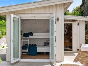 um pequeno barracão branco com uma cama no interior em 8 person holiday home in ELL S em Ellös
