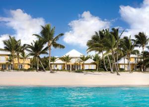 a row of houses on a beach with palm trees at Tortuga Bay in Punta Cana