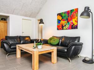 ヴィデ・サンデにある8 person holiday home in Hvide Sandeのリビングルーム(革張りのソファ、コーヒーテーブル付)