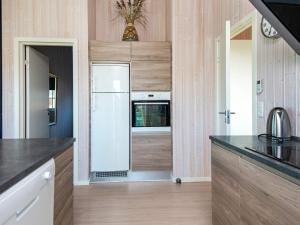 cocina con paredes de madera y nevera blanca en 10 person holiday home in Ansager en Ansager