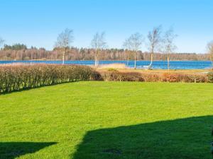 een groot grasveld met een meer op de achtergrond bij 10 person holiday home in Ansager in Ansager