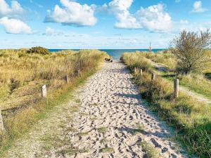 a dirt path leading to the ocean on a beach at 8 person holiday home in Gedser in Gedser