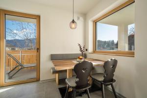 ein Esszimmer mit einem Tisch, Stühlen und einem Fenster in der Unterkunft sunnig Apartment Sonnenaufgang in Völlan