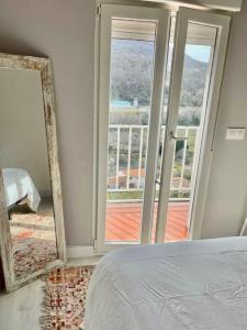 - une chambre avec un miroir, un lit et un balcon dans l'établissement El Rinconcito de Bejar, à Béjar