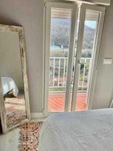 a bedroom with a mirror and a bed and a balcony at El Rinconcito de Bejar in Béjar