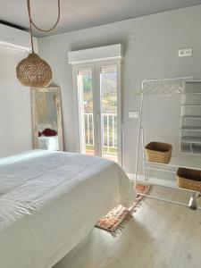 a white bedroom with a large bed and a window at El Rinconcito de Bejar in Béjar