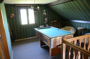 a pool table in a room with green stripes at Le Clos des Aulnes in Anould