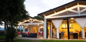 a house with white curtains and tables and chairs at Fattoria il Duchesco in Alberese