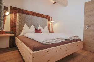 ein Schlafzimmer mit einem Bett mit einem Bettrahmen aus Holz in der Unterkunft Bamerhof Haus Steger in Mittersill