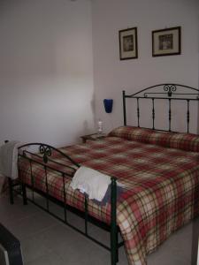 una camera con un letto con una coperta a quadri di Otranto Green House a Otranto