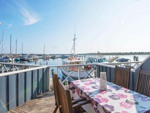 a table and chairs on a dock with boats at 6 person holiday home in Grenaa in Grenå