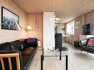 エスビャウにある6 person holiday home in Esbjerg Vのリビングルーム(革張りのソファ、テーブル付)