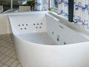 eine weiße Badewanne in einem Zimmer in der Unterkunft 12 person holiday home in Ebeltoft in Ebeltoft