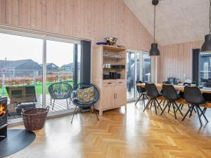 10 person holiday home in Haderslev في هادرسليف: غرفة معيشة مع طاولة وكراسي ونافذة كبيرة