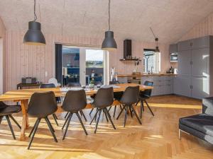 10 person holiday home in Haderslev في هادرسليف: مطبخ وغرفة طعام مع طاولة وكراسي خشبية