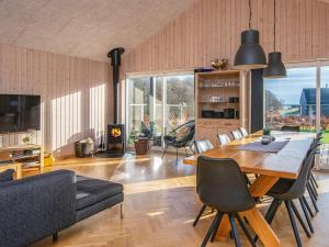 10 person holiday home in Haderslev في هادرسليف: غرفة معيشة مع طاولة طعام وأريكة