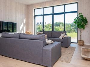 ein Wohnzimmer mit 2 Sofas und einem großen Fenster in der Unterkunft 16 person holiday home in Glesborg in Glesborg
