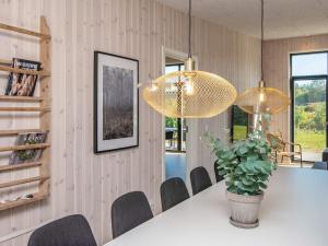a dining room with a table and two chandeliers at 16 person holiday home in Glesborg in Glesborg