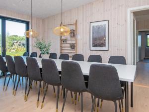 ein Esszimmer mit einem weißen Tisch und Stühlen in der Unterkunft 16 person holiday home in Glesborg in Glesborg