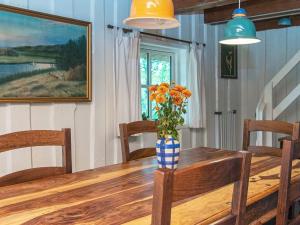 einen Esstisch mit einer Blumenvase darauf in der Unterkunft 7 person holiday home in R m in Lakolk