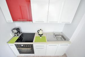 cocina blanca con fregadero y microondas en Harmony Residence, en Bucarest