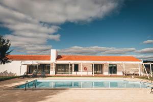 a building with a swimming pool in front of it at Vale Pisco in Bombarral