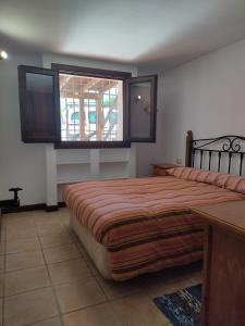 a bedroom with a large bed and a window at Casa Paulonia in Las Negras