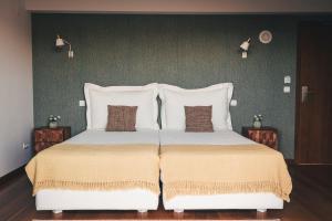 a bedroom with a large bed with two pillows at Vale Pisco in Bombarral