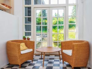 Duas cadeiras e uma mesa num quarto com uma janela em 6 person holiday home in Alling bro em Allingåbro
