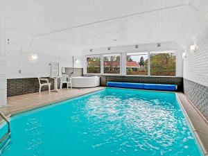 a swimming pool in a house with a kitchen and a dining room at Holiday home Glesborg LXV in Glesborg