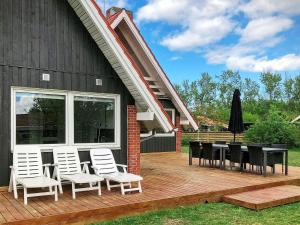 a wooden deck with a table and chairs on a house at Holiday home Glesborg LXV in Glesborg