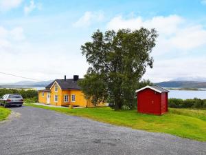uma casa com um barracão vermelho ao lado de uma estrada em 5 person holiday home in Skutvik em Skutvika