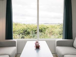 Zimmer mit einem Tisch, 2 Stühlen und einem Fenster in der Unterkunft 6 person holiday home in Thyholm in Thyholm