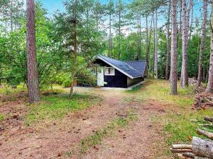 una pequeña casa en medio de un bosque en 7 person holiday home in Store Fuglede en Store Fuglede